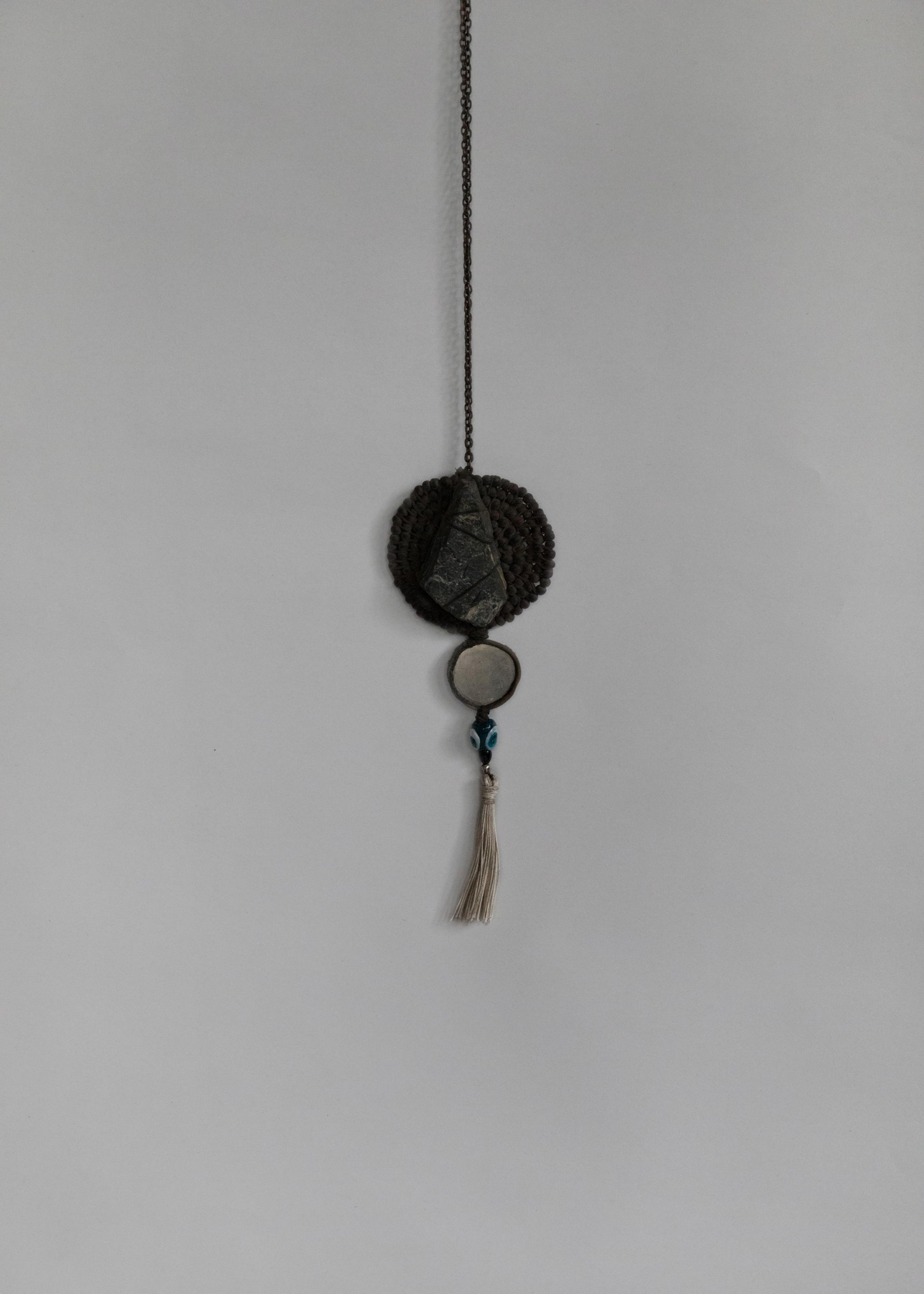 'Voting Pendant' made by Peachey and Mosig from rock, glass, thread, leather, copper, nickel, silver, and silk.